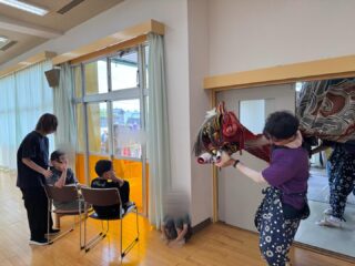 2026年5月23日（土）午前11時40分頃に今年も地域の皆様のご厚意により、お獅子が事業所に来てくださいました。迫力ある獅子舞に、子どもたちは驚いたり笑顔になったりしながら、興味津々で見入ってました。お獅子に頭を噛んでもらうと「無病息災」や「健やかな成長」の願いが込められていると言われており、子どもたち一人ひとりの健康と成長を願いながら、楽しい時間を過ごすことが出来ました。
日本の伝統行事に触れる貴重な機会となり、子どもたちにとって思い出深い経験になったことと思います。今後も季節の行事に触れて、地域とのつながりを大切にしながら、さまざまな体験を取り入れてまいりますのでよろしくお願い致します。

#aijyu松沢 
#AIJYU松沢
#放課後等デイサービス 
#児童発達支援 
#富山県